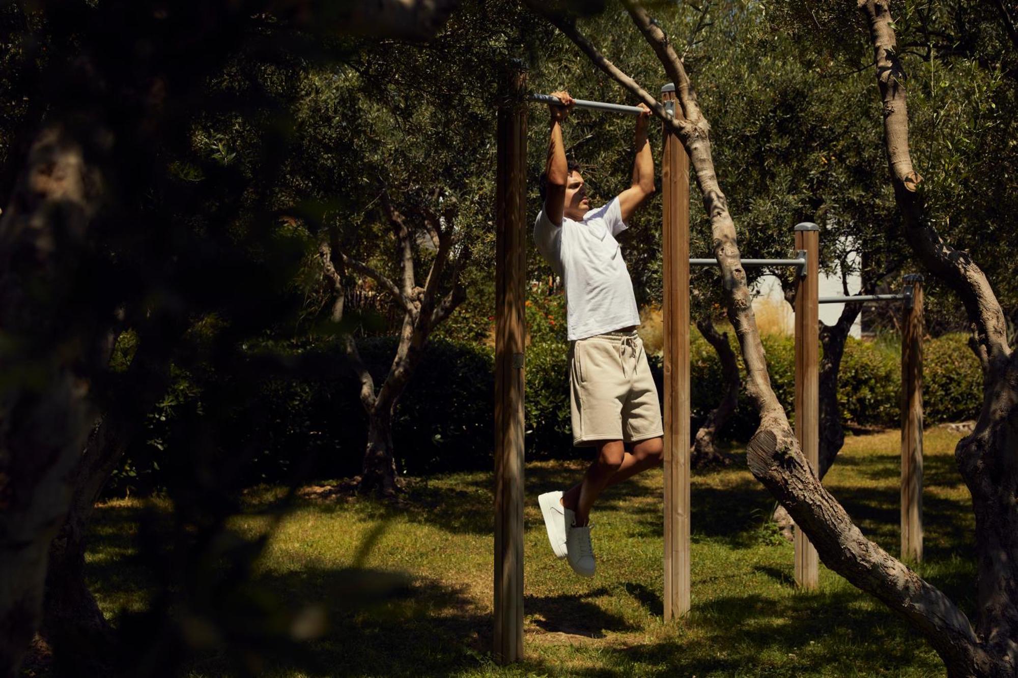 Minos Palace Resort - Adults Only Agios Nikolaos  Bagian luar foto A man doing pull-ups on a horizontal bar